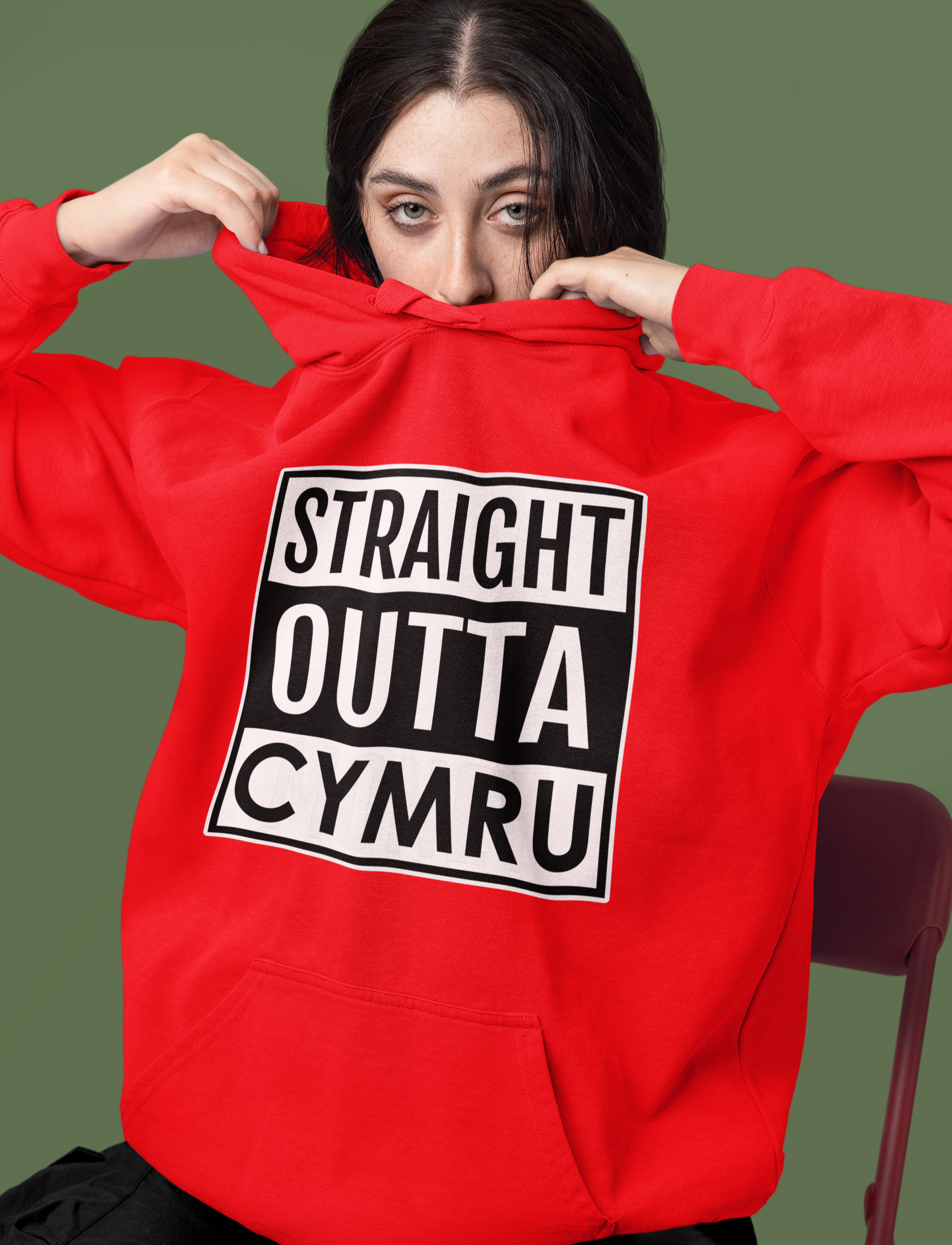 Person wearing a red hoodie with 'Straight Outta Cymru' text on a green background