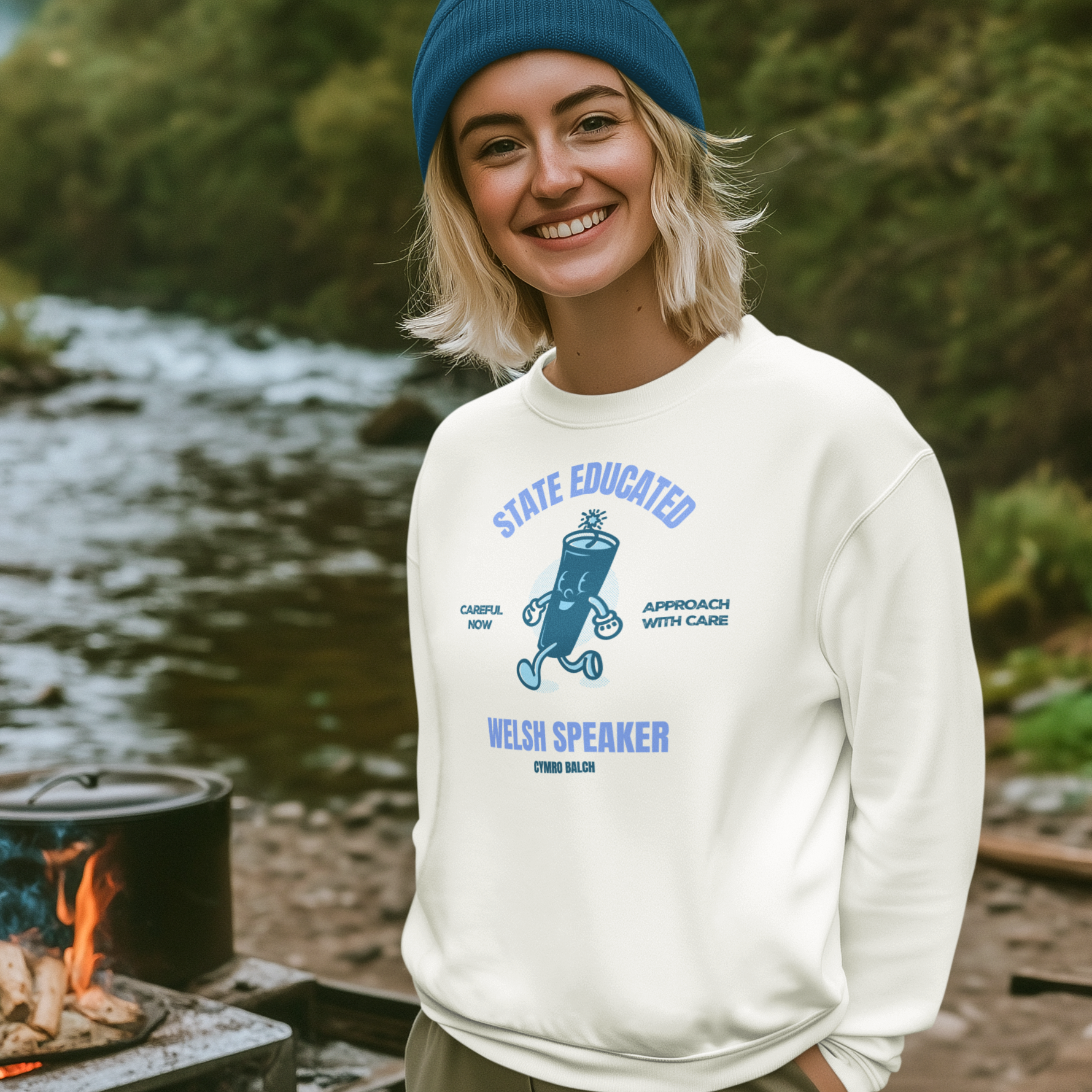 Person wearing a white sweatshirt with blue text and graphics, standing outdoors near a body of water.