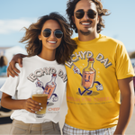 A man and a woman standing outdoors in sunglasses, each wearing a graphic T-shirt. The woman wears a white T-shirt with a dark gray 'IECHYD DA!' bottle graphic, and the man wears a bright yellow T-shirt with a matching bottle graphic.