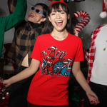 Four people celebrating at night with festive decorations. The central focus is a woman wearing a bright red graphic t-shirt with the Penscynor logo with all the animals wearing santa hats.