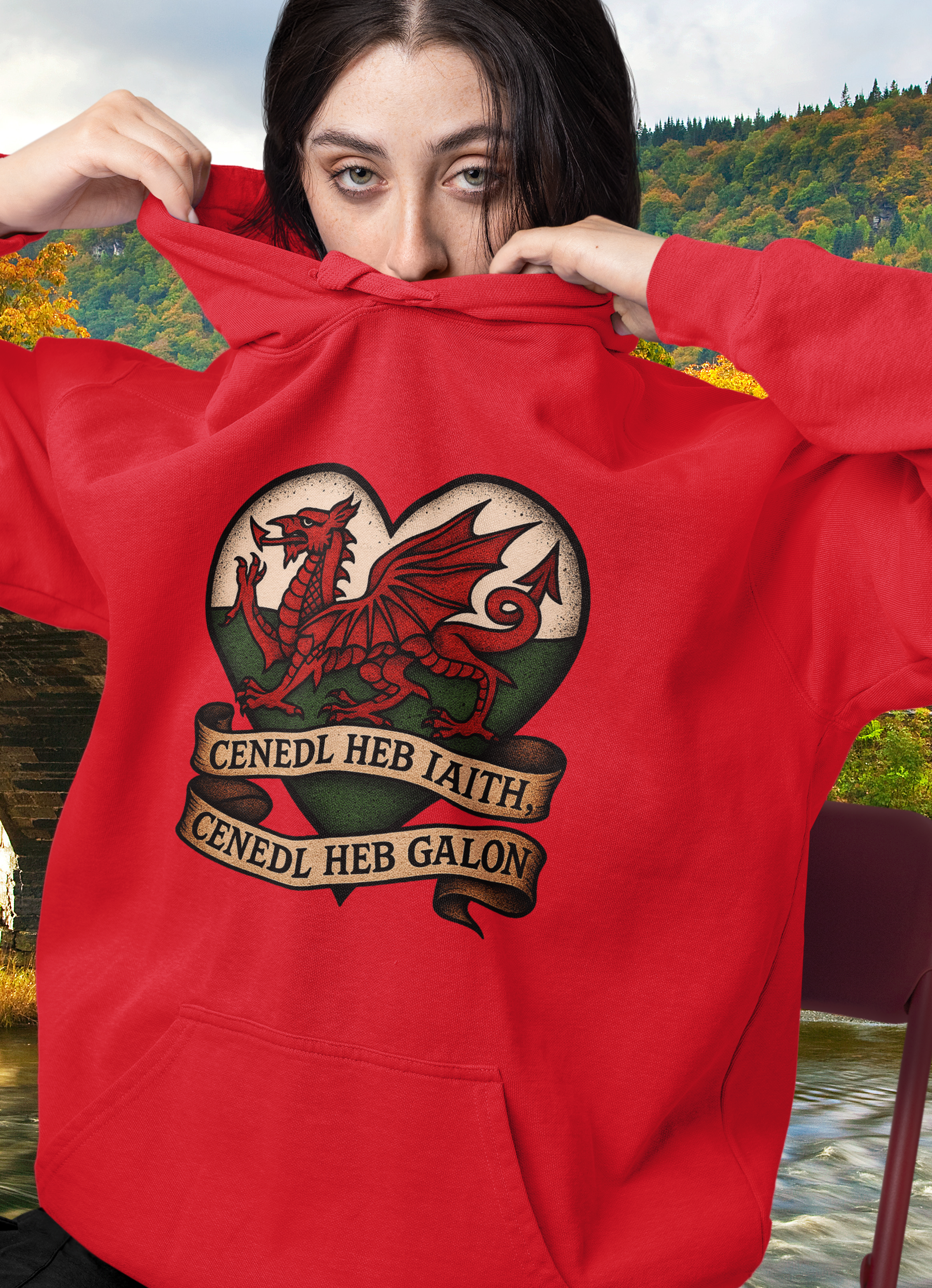 Person wearing a red hoodie with a dragon design in a scenic outdoor setting
