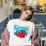 Model wearing GLF T-Shirt with red dragon design and 'Give Less' slogan, featuring a sunny background.