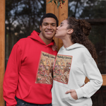 Two young adults posing in front of a rustic wooden door. The person on the left wears a bright red hoodie with a vintage Christmas card graphic on the front, and the person on the right wears a light gray hoodie with a matching graphic.