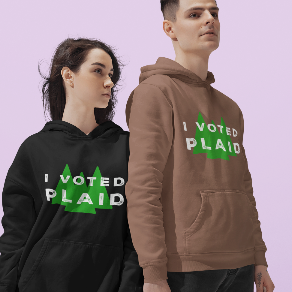 Two people wearing hoodies with 'I Voted Plaid' text on a light purple background