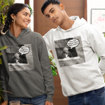 Two models wearing matching graphic hoodies in a modern indoor setting. The model on the left wears a dark gray hoodie, and the model on the right wears a light gray hoodie.