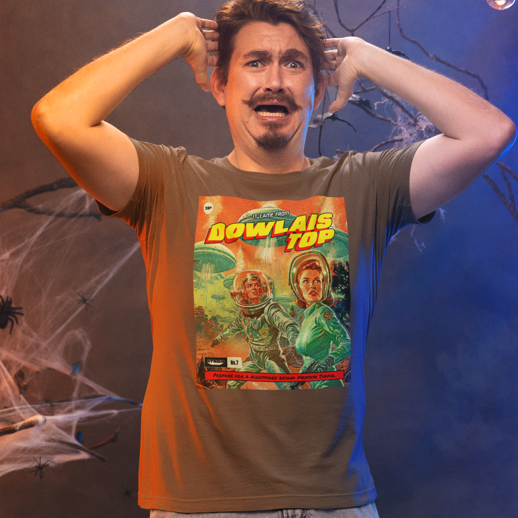 Person wearing a t-shirt with a graphic design, standing in front of a dark background with spider webs and light bulbs.
