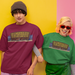 Two models wearing graphic t-shirts in purple and green, standing against a split yellow and pink background.