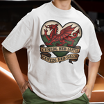 Person wearing a white t-shirt with a red dragon design and text, standing in front of a car.