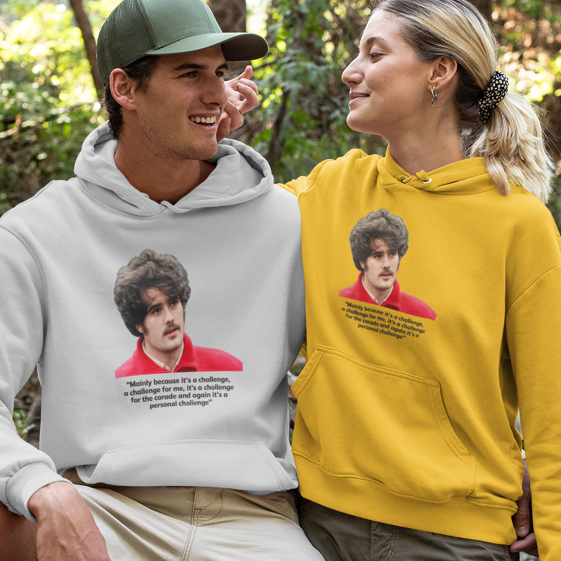 Two people wearing hoodies with printed images in a forest setting