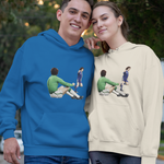 Two people wearing blue and beige hoodies with graphic designs outdoors.
