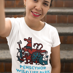 A woman wearing a white t-shirt with a colorful cartoon graphic of animals and the text 'PENSCYNOR WILDLIFE PARK', posing in front of outdoor brick steps.