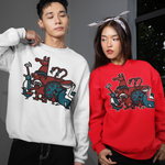 Two models wearing matching crewneck sweatshirts with a colorful graphic print. The model on the left wears a white sweatshirt, and the model on the right wears a bright red sweatshirt, both paired with black pants.