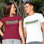 Two young adults standing outdoors and holding hands, wearing matching Aberhorndu graphic t-shirts. The woman wears a maroon t-shirt and the man wears a white t-shirt, both featuring a green landscape graphic with the text 'ABERHONDDU' across the chest.