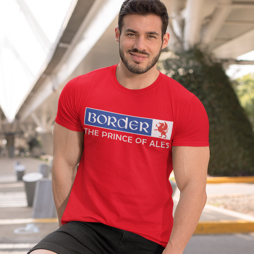 Man wearing a red t-shirt with a brand logo, standing outdoors on a city street.