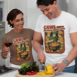 A man and a woman in a modern kitchen, both wearing matching graphic t-shirts featuring a cartoon character in a pot with the text 'CAWL It's more than a stew'. The man is cutting a yellow bell pepper on a wooden board, while the woman holds a glass of red wine.