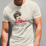 Man wearing a t-shirt with a graphic design against a gray wall